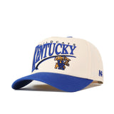 The No Rivals Kentucky Wildcats Stride Hat is a white and blue snapback featuring the UK logo and wildcat mascot embroidered in blue and gold on the front. Made from high-quality cotton, this structured fit hat combines style and comfort—perfect for any Wildcats fan.