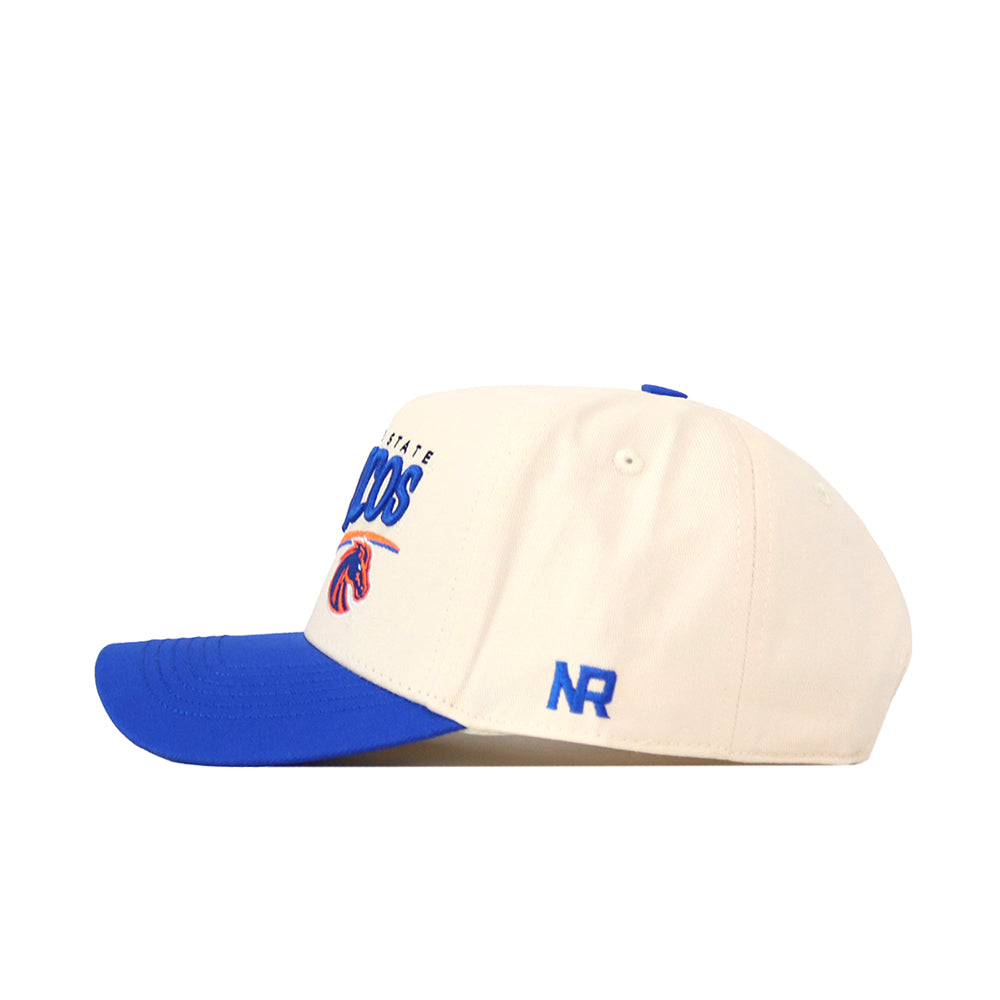 The No Rivals Boise State Broncos Stride Hat is a cream-colored snapback with a blue bill, blue top button, and detailed embroidered logos—including “NR” on the side and a stylized buffalo logo on the front.
