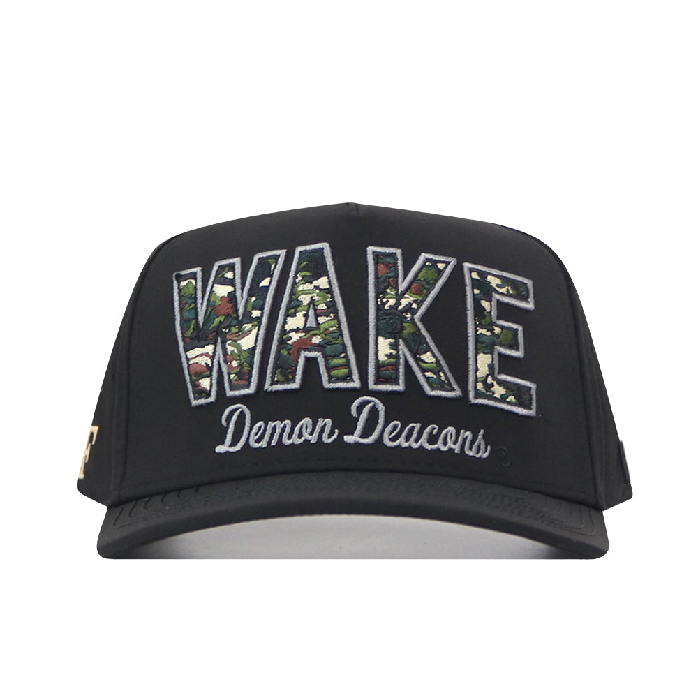 The No Rivals Wake Forest Camo Block Hat is a black snapback featuring bold, camouflage-patterned “WAKE” lettering with “Demon Deacons” embroidered in white script underneath on the front—making it the perfect standout gameday accessory with eye-catching embroidered logos.