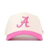 The Alabama Pink Out Hat by No Rivals is a white snapback with a pink brim and an embroidered letter A, shown on a white background—an officially licensed breast cancer hat.