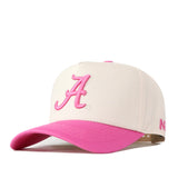 The Alabama Pink Out Hat by No Rivals features a white snapback with a pink brim and an embroidered pink letter A—perfect as a stylish breast cancer hat.