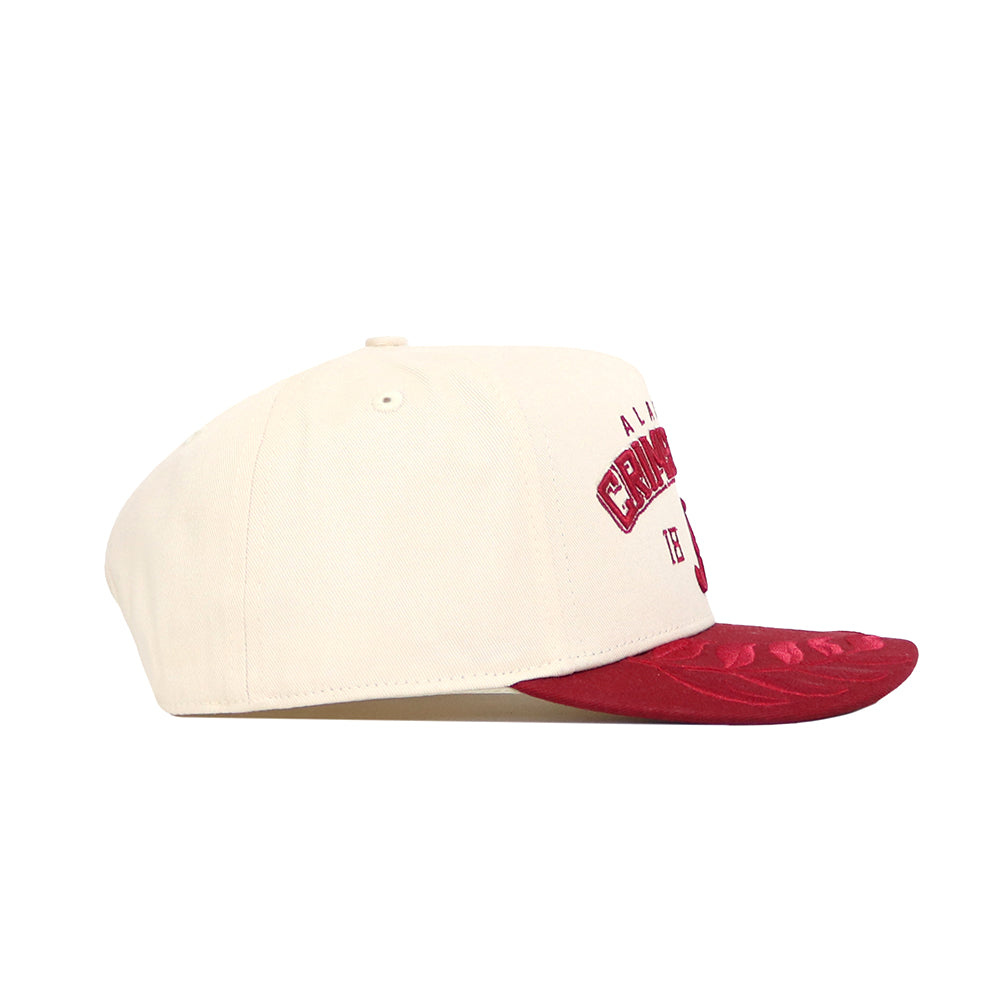 The Alabama Rally Hat by No Rivals is a cream snapback made from premium cotton, featuring a red brim and front embroidery. Displayed in side view against a white background.