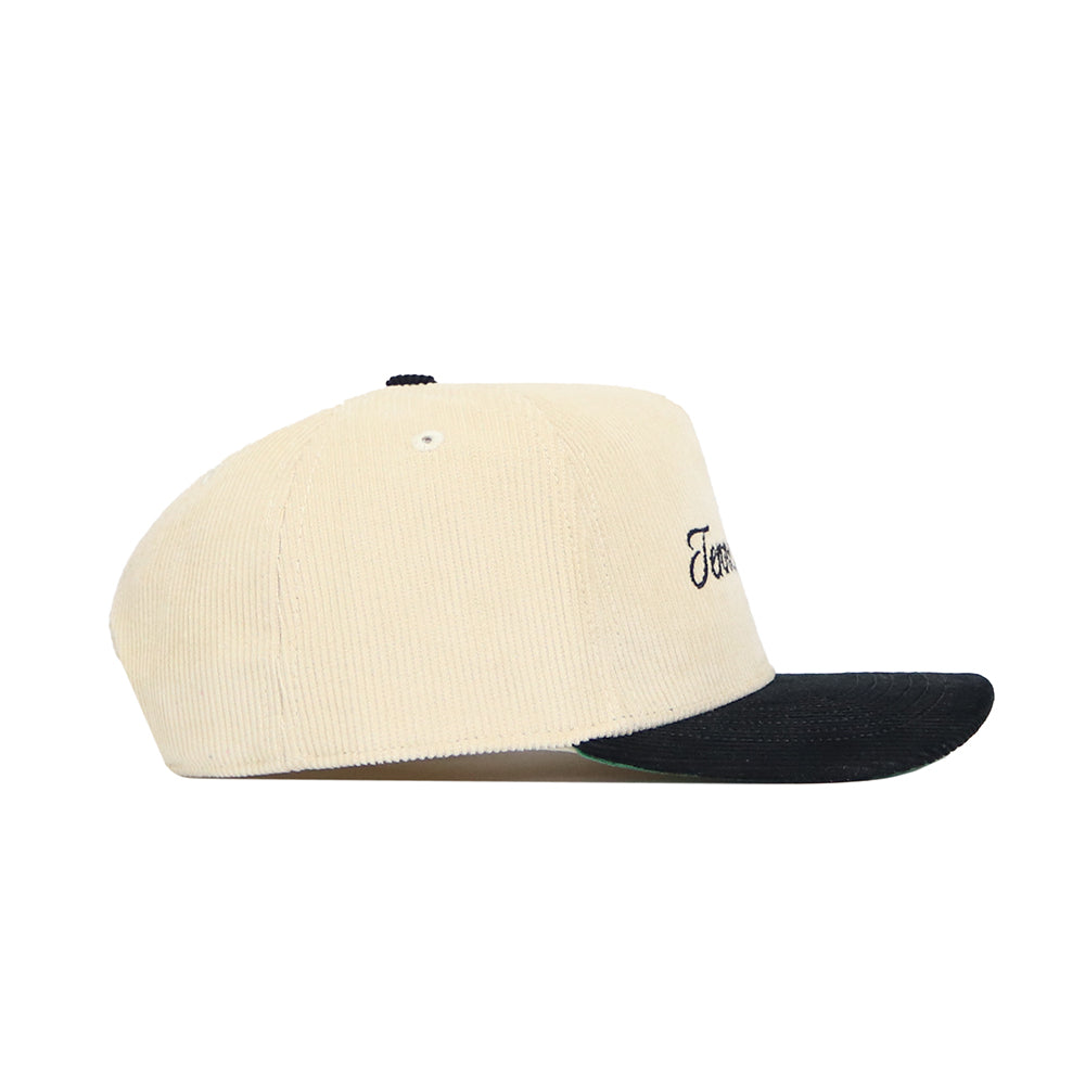 Side view of the Tennessee Traditions Hat by No Rivals, a beige corduroy hat with a structured fit, black curved brim, small black top button, and partially visible text on the front panel.