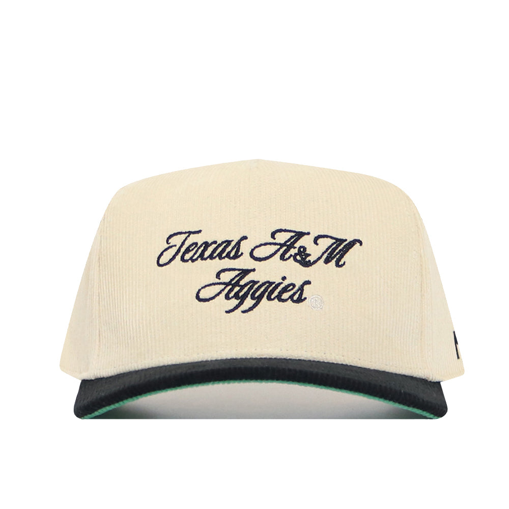The No Rivals Texas A&M Traditions Hat is cream corduroy with "Texas A&M Aggies" in black script, a structured fit, black brim with green underside, and an adjustable snapback.