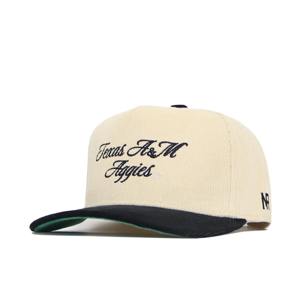 The No Rivals Texas A&M Traditions Hat is a beige corduroy cap with a black brim, Texas A&M Aggies embroidered in black script, small N and F logos on the side, and a structured fit for lasting style.