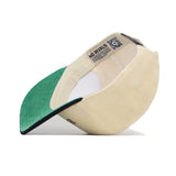 The Alabama Traditions Hat by No Rivals is shown upside down, revealing its interior label and a QR code near the adjustable strap. This beige and green snapback, crafted from high-quality cotton, delivers both comfort and style.