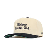 The Alabama Traditions Hat by No Rivals is a cream snapback with a structured fit, black brim, green underbill, and "Alabama Crimson Tide" embroidered in black script. Features black "NF" initials on the side and is made from high-quality cotton.