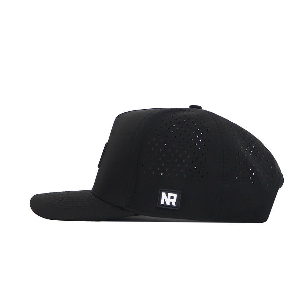 The Texas A&M Trainer Hat by No Rivals is a black snapback viewed from the side, featuring a structured fit, small ventilation holes on the crown, and a rectangular NR patch on the side.