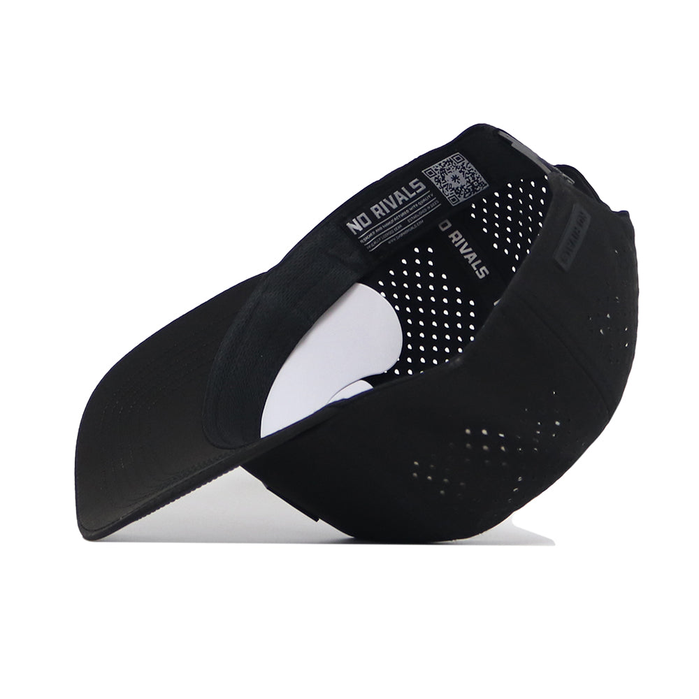 The Texas A&M Trainer Hat by No Rivals is shown upside down, revealing an interior label with the NO RIVALS logo and a QR code. This black cap features performance material, side ventilation holes, and a curved brim.