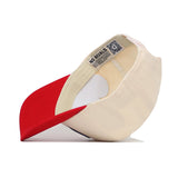The Utah Logo Patch Hat by No Rivals features a beige snapback design with a red brim, bold 3D embroidery, and an inner label printed with "NO RIVALS" and a QR code, shown upside down to display the unique details.