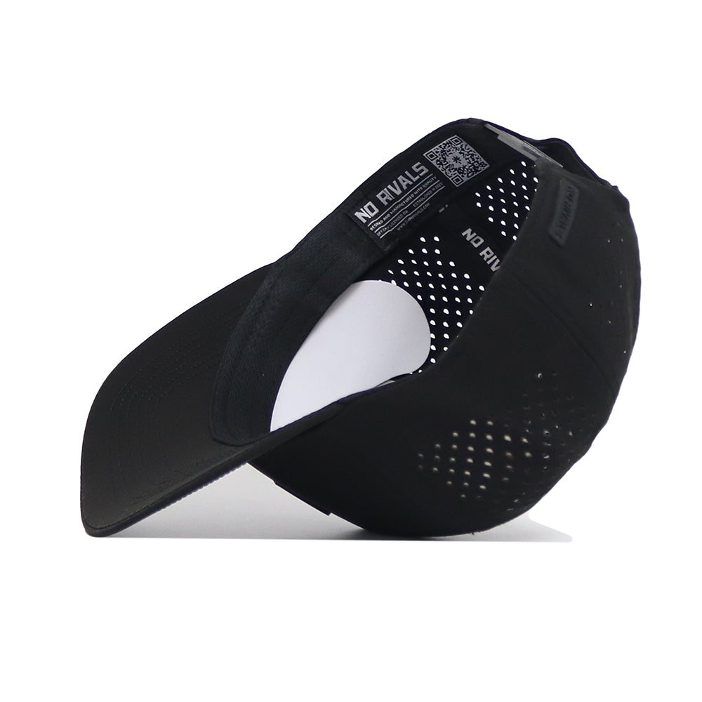 The Indiana Trainer Hat by No Rivals is a black mesh baseball cap shown upside down on a white surface, displaying the inside NO RIVALS label, ventilation holes on the back and sides, and a Snap Back Adjustment.