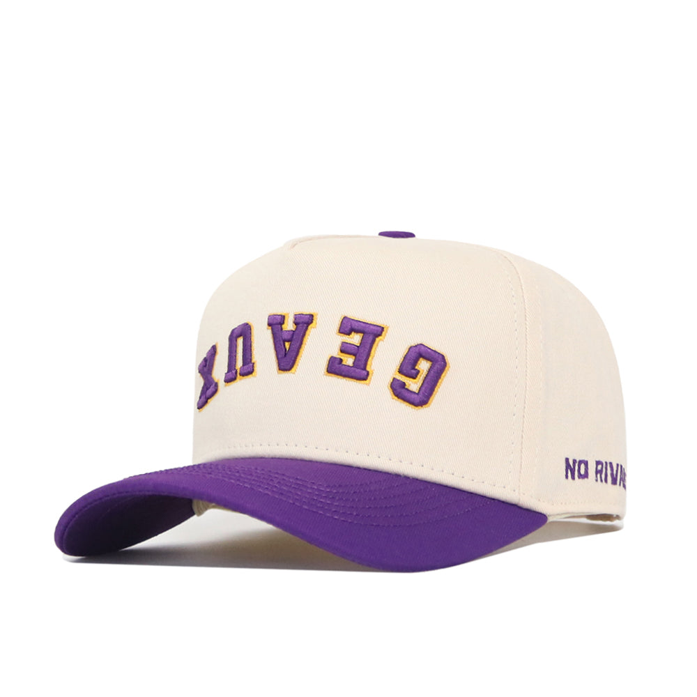 The Upside Down Geaux Hat - LSU - Classic by No Rivals is a cream baseball cap with a purple brim, structured fit, and adjustable snapback. GENX is embroidered upside down in purple and gold on the front; NO RIVAL stitched on the side.