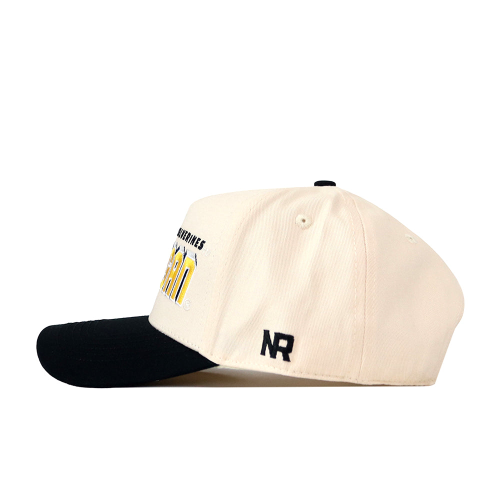 A side view of the Michigan Wolverines Alma Mater Hat by No Rivals is shown, featuring a cream color with a black brim and an embroidered “NR” logo in black on the side. Partially visible yellow and black lettering decorates the front, and its adjustable snapback design makes it perfect for your gameday look.
