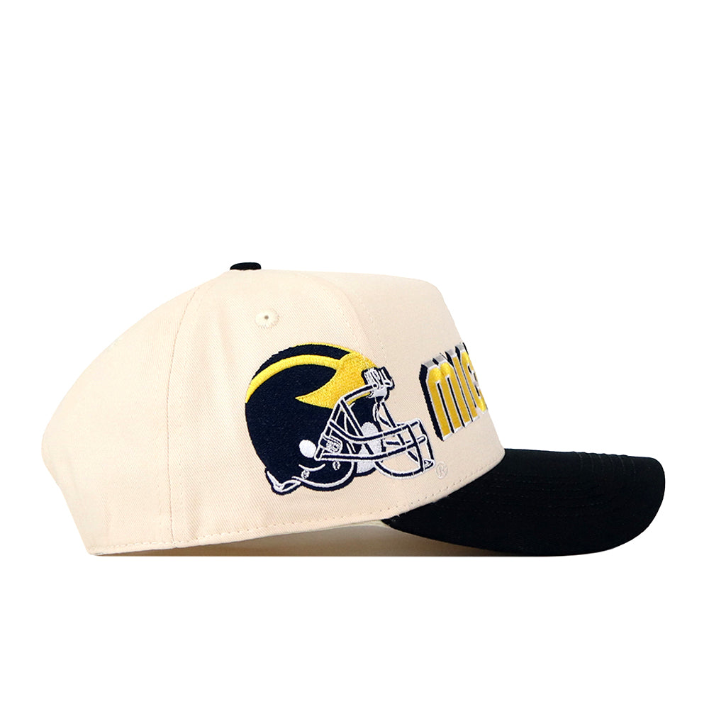 Show your Michigan pride with the No Rivals Michigan Wolverines Alma Mater Hat—a beige snapback cap featuring a black brim, large yellow and navy embroidered text, and a detailed football helmet design in navy and yellow on the side. The perfect finishing touch for your gameday fit!.
