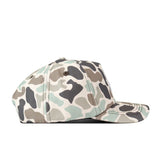A side view of the No Rivals Texas State Huntsman Hat with a green, beige, brown, and black camouflage pattern against a white background showcases its stylish snapback design and embroidered logo—perfect for completing your gameday fit.