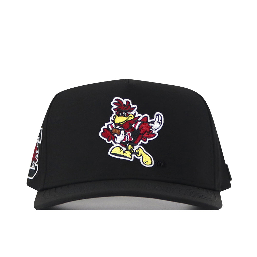 The South Carolina Gamecocks Football Mascot Hat in black by No Rivals showcases a cartoonish bird mascot dressed in yellow shoes and a red and yellow outfit, embroidered on the front. Featuring a snapback design for an adjustable fit, this hat’s bold logo embroidery adds standout character.