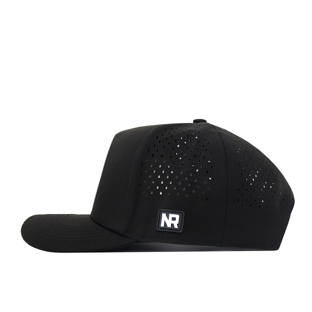 A Michigan State Spartans Football Mascot Hat in black by No Rivals, crafted from performance fabric with small ventilation holes and an NR logo patch on the left side, is shown from the side against a white background.