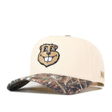 The Minnesota Gophers Camo Connector Hat by No Rivals features an officially licensed cartoon beaver face on the front, a beige crown, a camouflage-patterned brim, and a classic snap back closure.