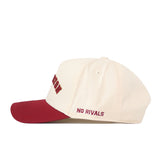 The Right Side Up Charleston Hat - Classic by No Rivals is a cream and maroon snapback cap viewed from the side. The maroon brim complements the bold “NO RIVALS” text embroidered in maroon above it, while an embroidered logo design adds to its standout appearance.