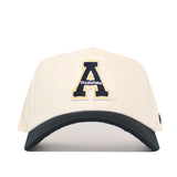 The No Rivals App State Logo Patch Hat - Block A is a cream snapback with a black visor, highlighted by a bold black and gold outlined “A” logo and official embroidered branding.
