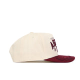 The Texas A&M Rally Hat by No Rivals is a cream snapback with a maroon brim, made from high-quality cotton. The front features partial maroon TEXAS AG embroidery, shown here in a side profile view.