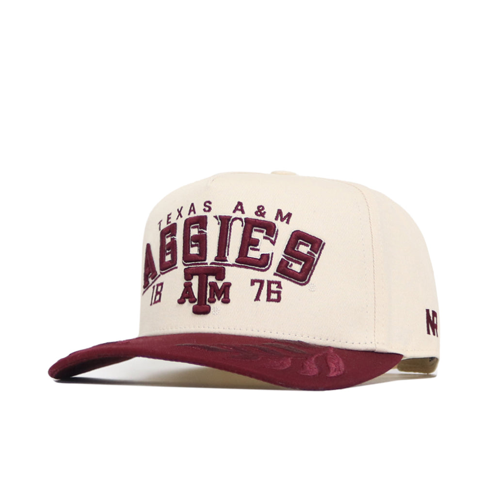 The No Rivals Texas A&M Rally Hat features a beige and maroon snapback design with high-quality cotton, “Texas A&M Aggies” and “1876” embroidered on the front, a center logo, and a maroon visor with glossy under accents.