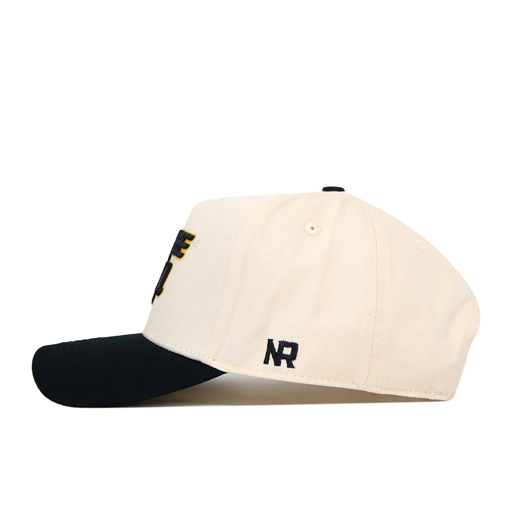 The Wichita State Patch Hat by No Rivals is a cream snapback with a black brim, NR embroidered on the side, and black and gold front lettering, crafted from high-quality cotton.