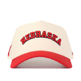 The No Rivals Right Side Up Nebraska Hat - Classic is a white and red snapback, made from high-quality cotton, with NEBRASKA boldly embroidered in red and black on the front.