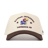 The Kansas Jayhawks Outlaw Hat - Classic by No Rivals is a beige cap with a brown brim, showcasing the Kansas Jayhawks logo along with "KANSAS JAYHAWKS," "1865," and "LAWRENCE, KS" embroidered on the front. Made from high-quality cotton and finished with detailed embroidered logos, this hat features a convenient snapback adjustment for a comfortable fit.