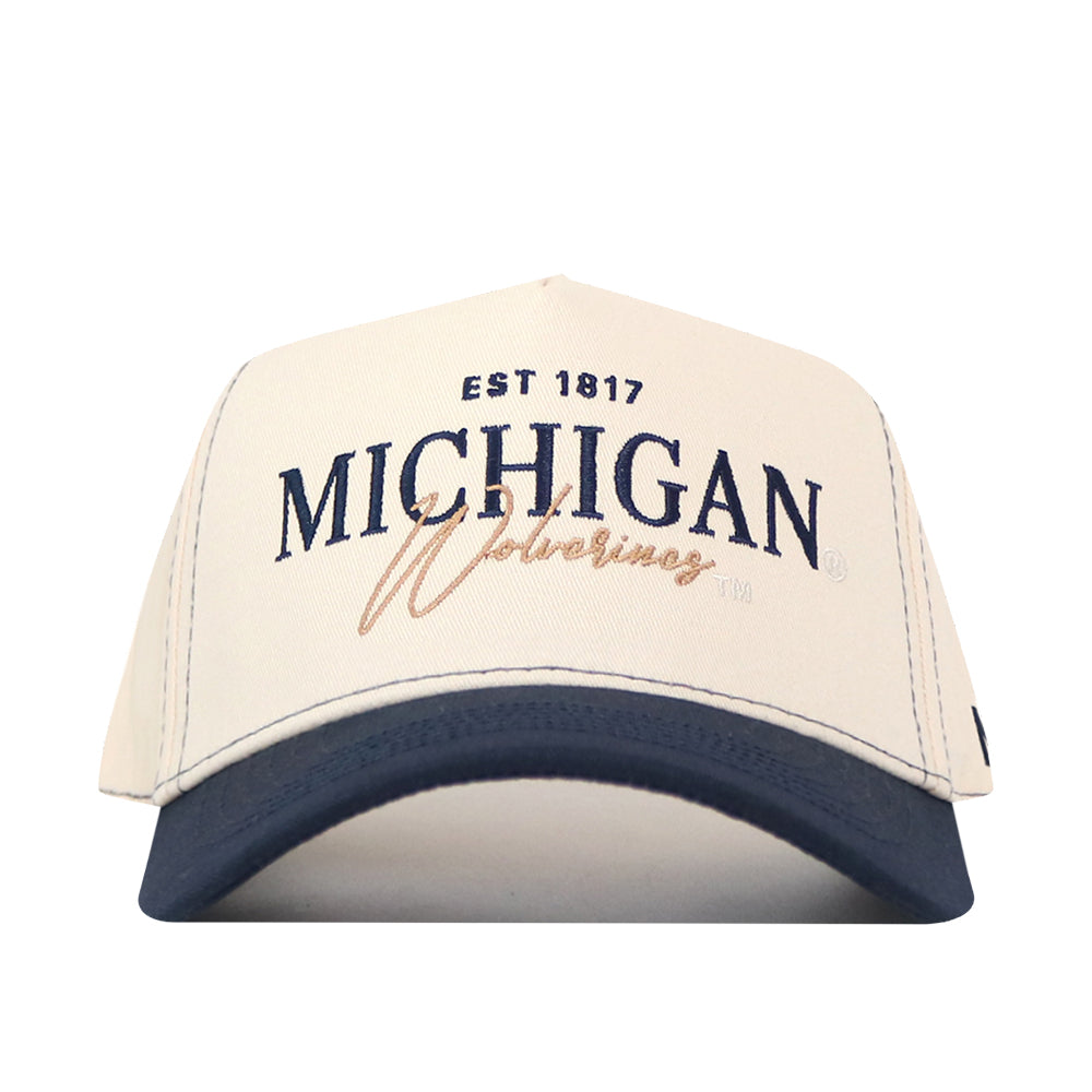 The No Rivals Michigan Wolverines Vintage Hat is a white and navy baseball cap featuring an embroidered “EST 1817 MICHIGAN Wolverines” logo in blue and gold on the front, with an adjustable snap back closure.