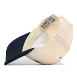 A beige and navy blue Michigan Wolverines Vintage Hat by No Rivals is turned inside out, displaying the label with the text “NO RIVALS” and a QR code on the inner band. This officially licensed cap features a classic snapback closure for an adjustable fit.