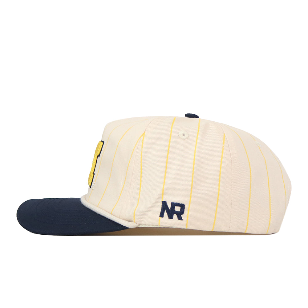The Michigan Wolverines Pinstripe Hat by No Rivals features a crisp white design with thin yellow stripes and a dark blue brim. An embroidered NR logo in blue accents the side, while the snap back adjustment ensures customizable comfort and a perfect gameday fit.