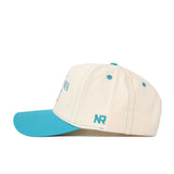 The OSU N7 Vintage Hat by No Rivals features a cream cotton build, turquoise brim and button, blue NR side logo, blue panel stitching, and an adjustable snapback for a perfect fit.