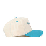 The OSU N7 Vintage Hat (B2B) by No Rivals is a cream-colored structured fit hat with a teal brim, button, and stitching, made from high quality cotton. Viewed from the side, it shows partially visible front text.