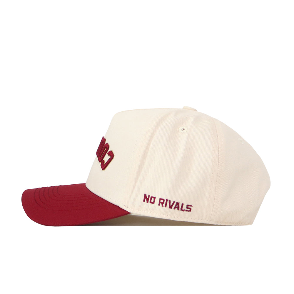 Sure! Here’s a rewritten version using the provided product data: The College of Charleston | Upside Down Cougars Hat - Classic by No Rivals is a cream-colored snapback with a red brim, featuring “NO RIVALS” embroidered in red on the side.