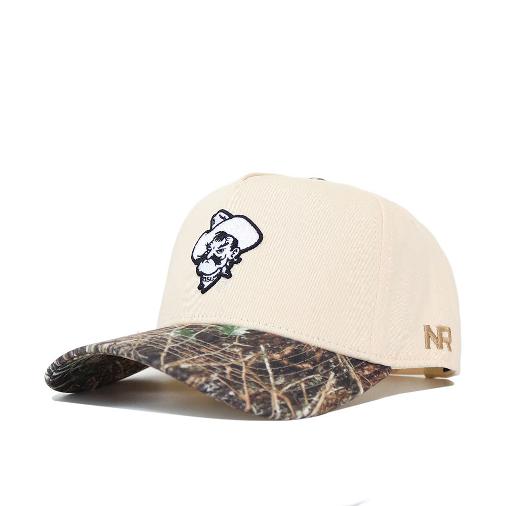 The OSU Pistol Pete Camo Hat - Connector Edition by No Rivals is a beige snapback with a camo brim, features an embroidered cartoon cowboy face on the front and gold NR initials on the side, and is crafted from high-quality cotton for comfort and durability.