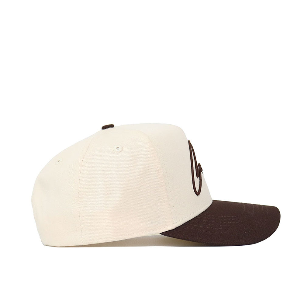 The Cowboys Script Espresso Hat by No Rivals is a cream-colored cotton baseball cap with a brown curved brim and brown embroidered text, shown from the side against a white background.