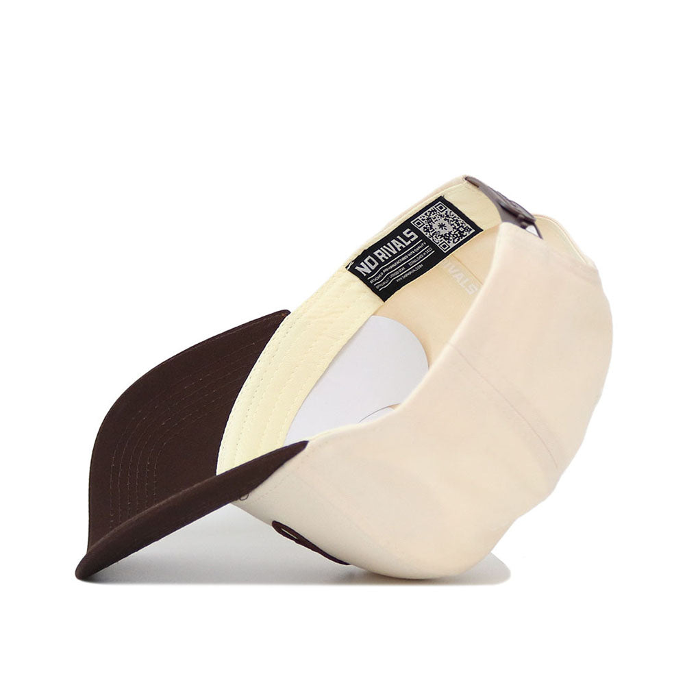 The Cowboys Script Espresso Hat by No Rivals features a cream and brown snapback design, curved brim, mesh sides, inside label with NO RIVALS text and a QR code. Made from premium cotton—ideal for your next gameday look.
