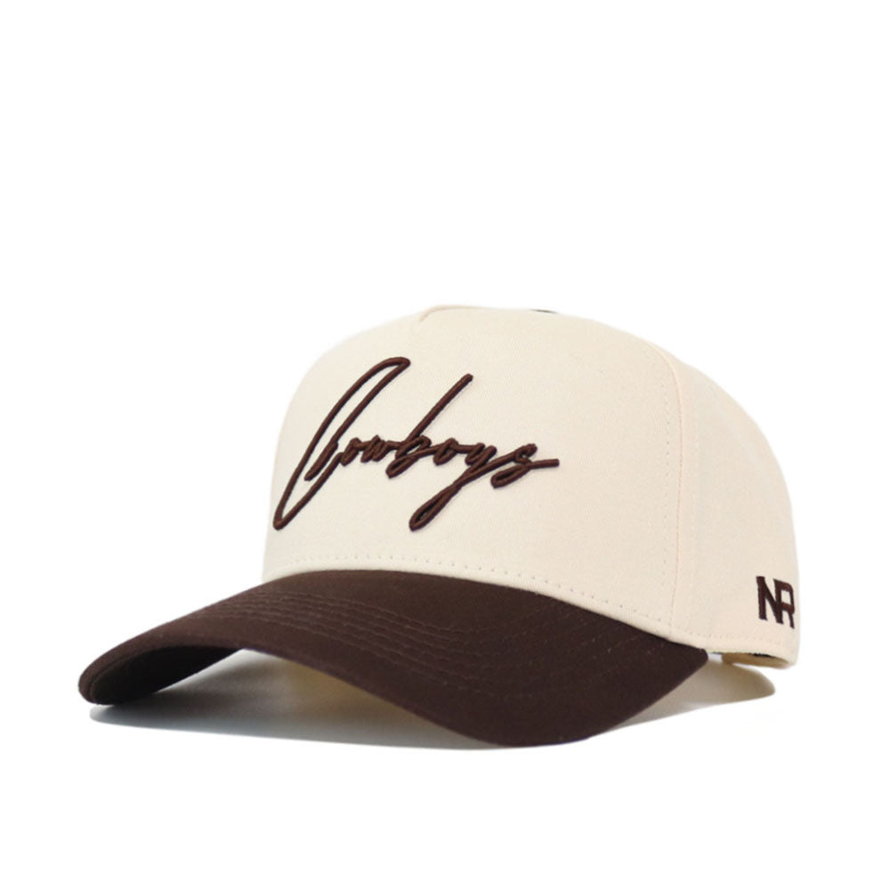 The Cowboys Script Espresso Hat (B2B) by No Rivals features beige and brown colors, "Cowboys" in cursive on the front, NR on the side, and is crafted from high-quality cotton for a perfect gameday fit.