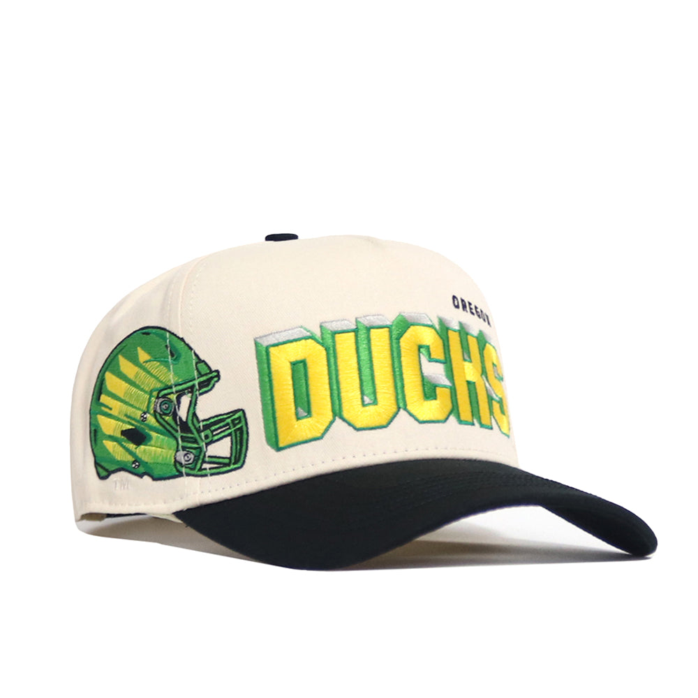 The No Rivals Oregon Alma Mater Hat is a white and black snapback with a green football helmet and large yellow and green "DUCKS" embroidery, plus "OREGON" in smaller text above.