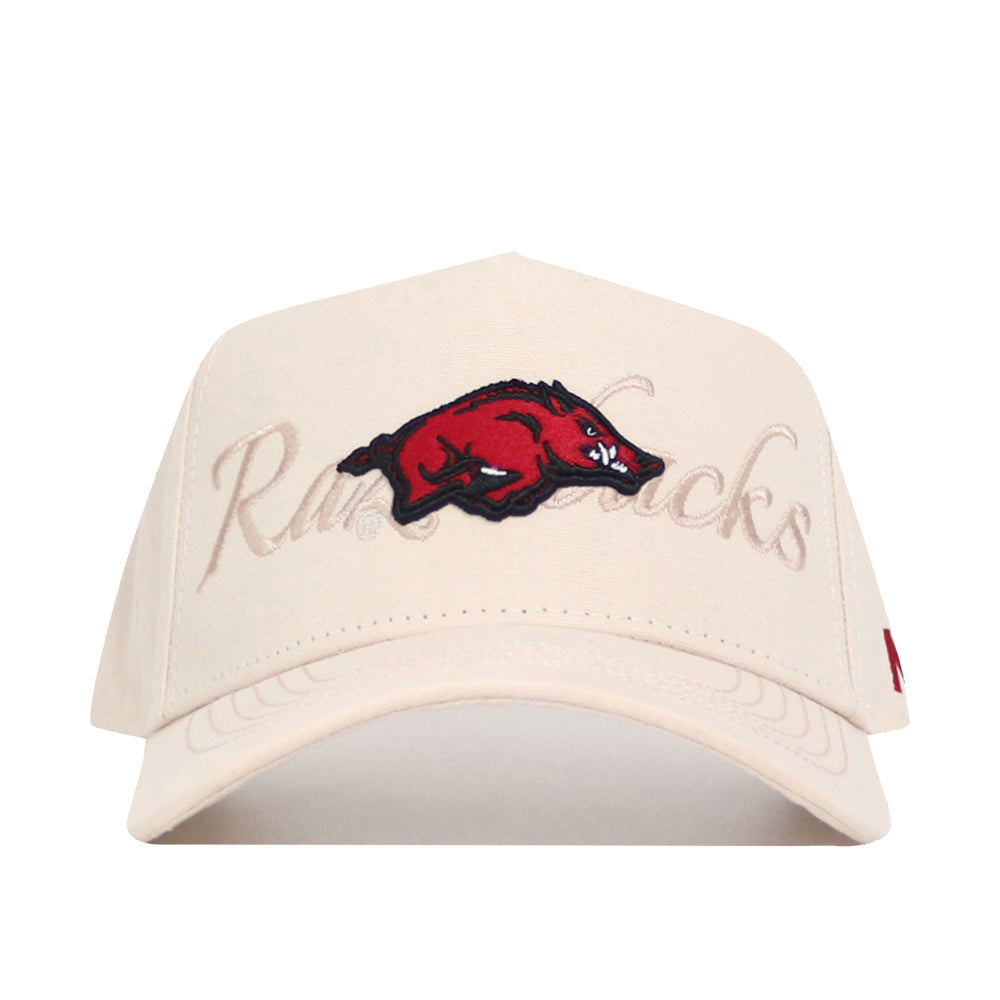 The No Rivals Arkansas Stacked Hat is a beige cotton baseball cap with an embroidered red razorback hog logo on the front and “Razorbacks” subtly stitched in beige behind the logo.