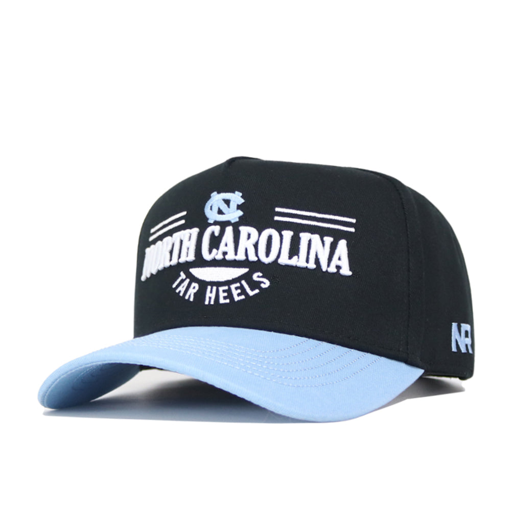 The North Carolina Tailgate Hat by No Rivals is a black and light blue snapback with the Tar Heels logo, NC, and NORTH CAROLINA TAR HEELS text embroidered on the front. Made of high-quality cotton for a structured fit.