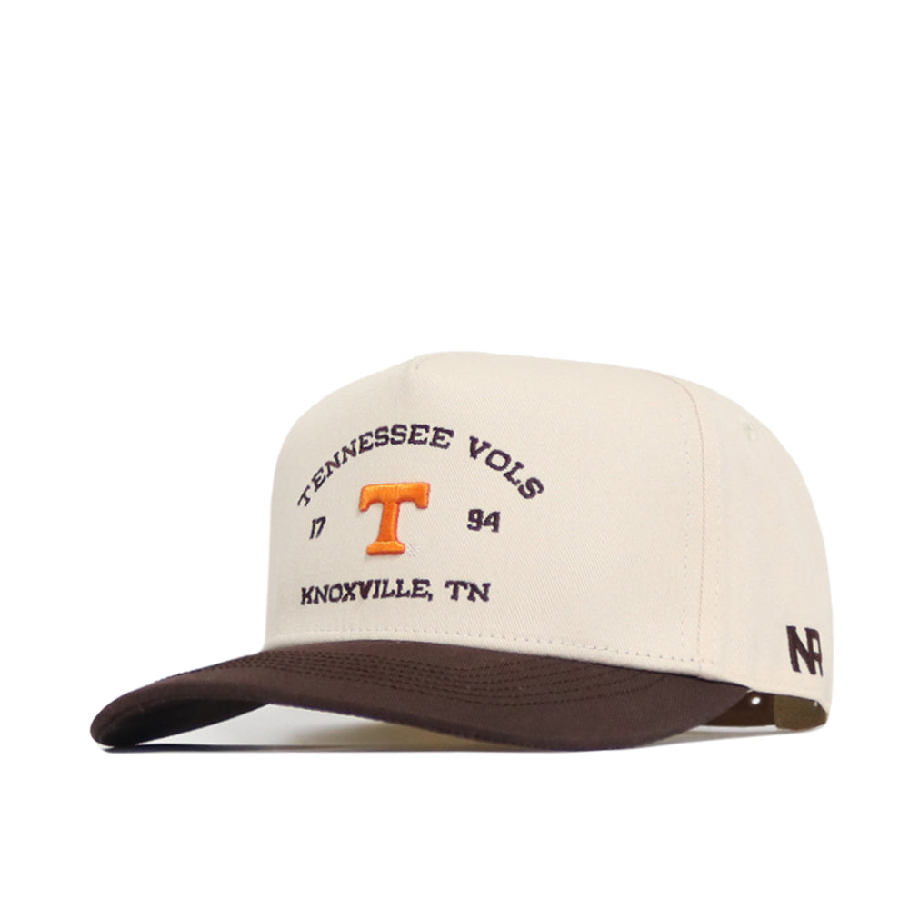 The Tennessee Outlaw Hat - Classic by No Rivals is a cream and brown snapback crafted from high-quality cotton, with "Tennessee Vols 1794 Knoxville, TN" and an orange T logo embroidered on the front plus a black N logo on the bill.