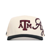 The No Rivals Texas A&M Halftime Hat is a cream baseball cap featuring embroidered maroon A and TM logos with script, crafted from high-quality cotton for a structured fit. Includes an adjustable snapback closure.