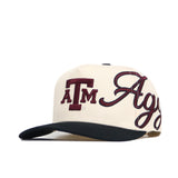 The No Rivals Texas A&M Halftime Hat is a cream snapback with a structured fit, black brim, bold maroon "ATM" embroidery, and "Aggies" in cursive across the front and side.