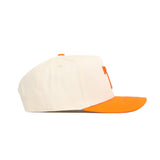 The No Rivals Tennessee Halftime Hat features a structured fit snapback with a cream crown, orange brim, button, and eyelets. Made from high-quality cotton, it's shown on a white background.