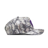 The No Rivals Kansas State Outland Hat is shown in a side view. This structured, cotton snapback features a woodland camouflage pattern, flat brim, and a partially visible purple front logo.