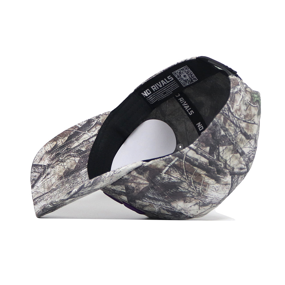 The Kansas State Outland Hat by No Rivals is a structured snapback with a classic woodland camo pattern, shown upside down to display the inside band labeled NO RIVALS. Made from high-quality cotton for comfort and style.