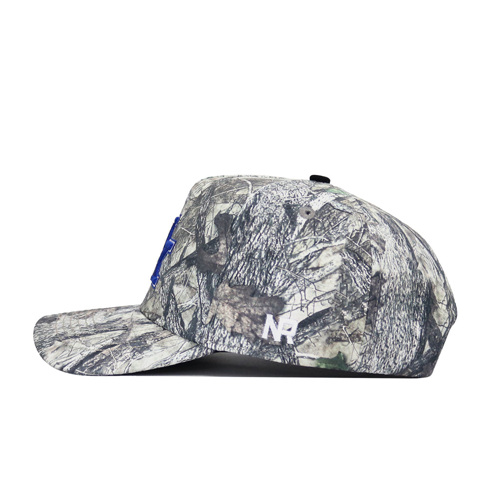 The No Rivals Kentucky Outland Hat is a high-quality cotton snapback with a camouflage pattern, flat brim, blue embroidered letter on the front, and white NR letters on the side panel for a structured fit.