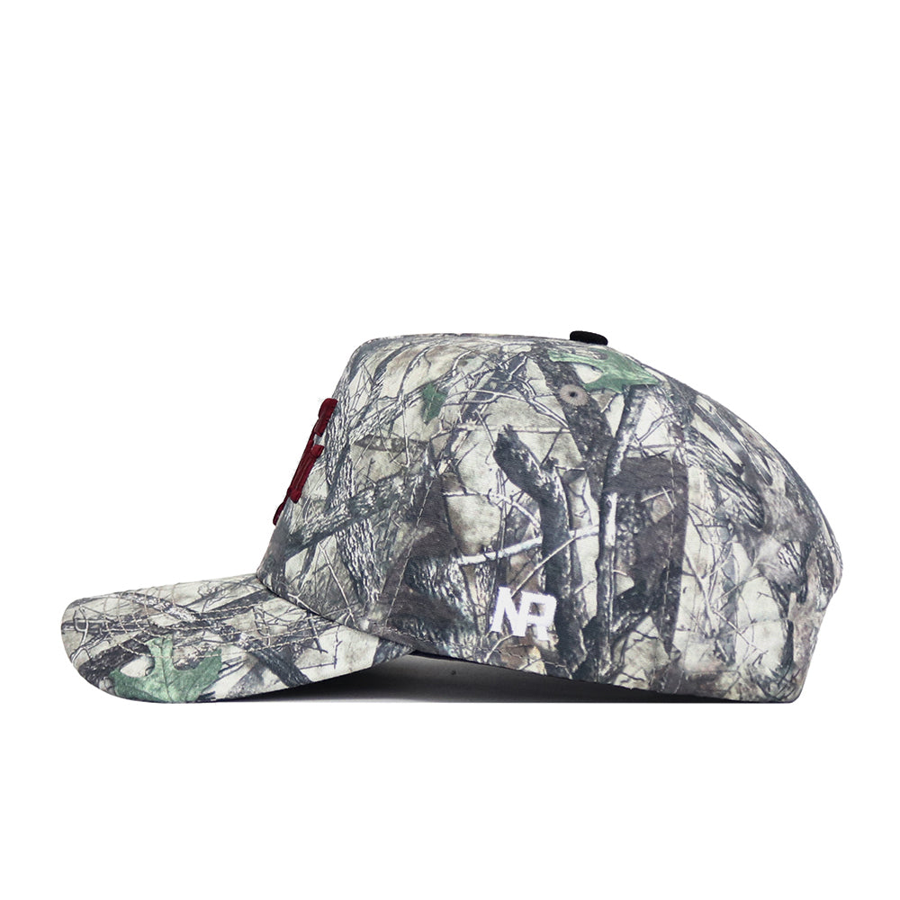 A side view of the No Rivals Texas A&M Outland Hat, a high-quality cotton snapback with a green and brown camo pattern and white MR lettering on the side.